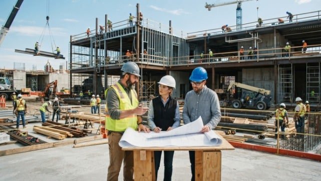 What is general construction illustrated by a contractor reviewing building plans and managing an active construction project.
